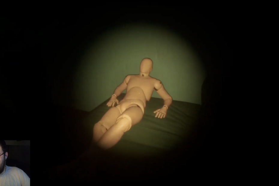 Eine Schaufenster-Puppe in lasziver Pose ist zu sehen. Die Puppe liegt auf einer Art Bett.